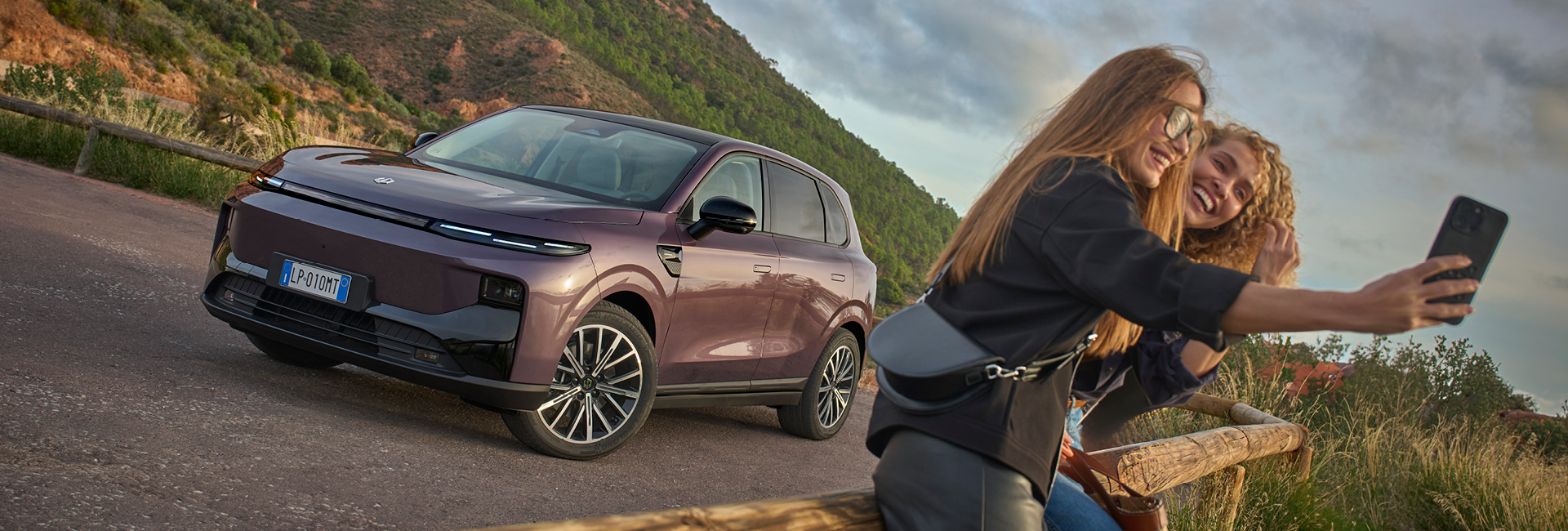 Leapmotor B10 SUV i färgen Dawn Purple parkerad på kullerstensgata framför en tegelbyggnad och en person som går förbi